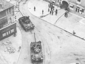 American Firefly tanks roll through a Normandy town - click to enlarge American Firefly tanks roll through a Normandy town